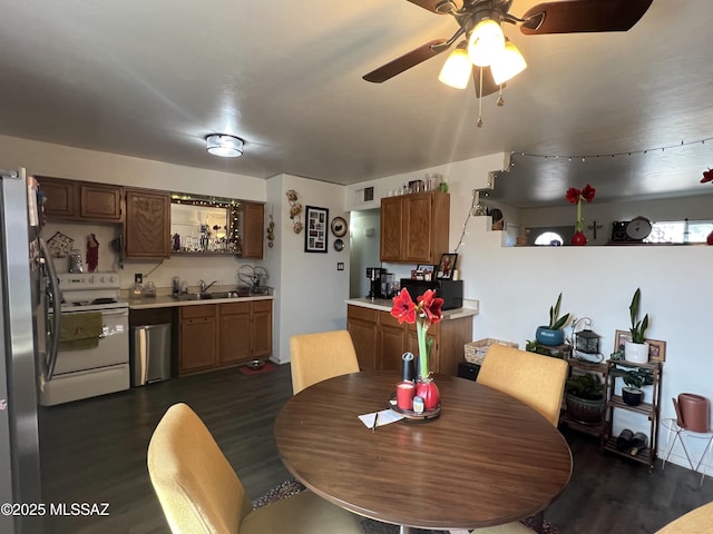 dining space featuring wet bar, dark hardwood / wood-style floors, and ceiling fan