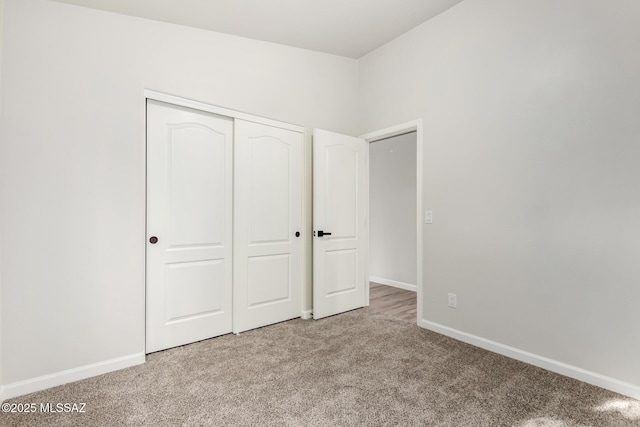 unfurnished bedroom with a closet and light carpet