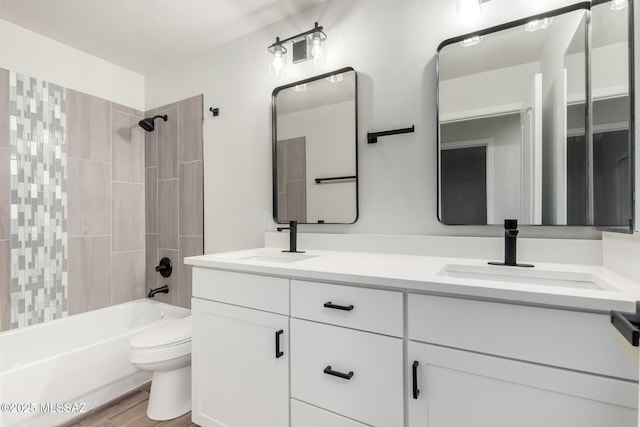 full bathroom featuring tiled shower / bath combo, hardwood / wood-style floors, toilet, and vanity