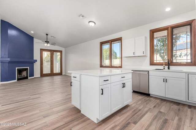 kitchen featuring sink, dishwasher, white cabinets, and light wood-type flooring