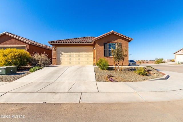 ranch-style house with a tile roof, concrete driveway, a garage, and stucco siding