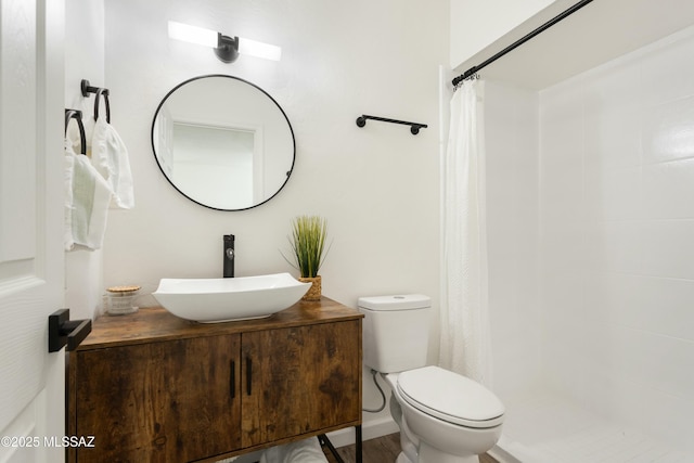 bathroom with toilet, a shower with shower curtain, and vanity