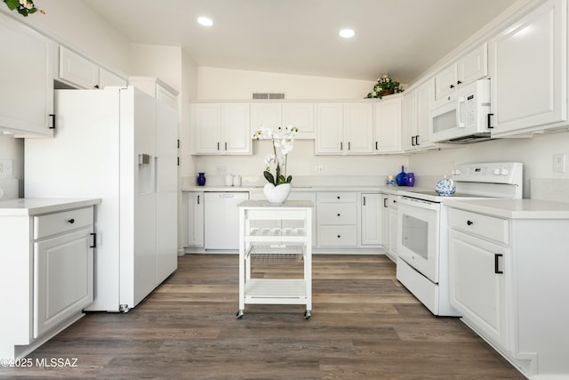 kitchen featuring white appliances, white cabinets, and lofted ceiling