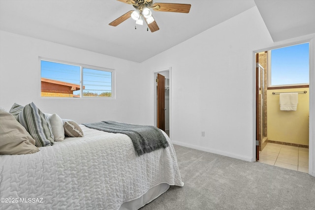 carpeted bedroom featuring ceiling fan, lofted ceiling, and ensuite bath