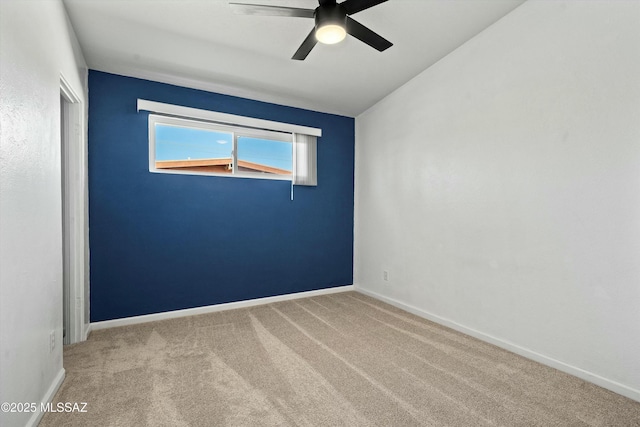 empty room featuring ceiling fan and light colored carpet