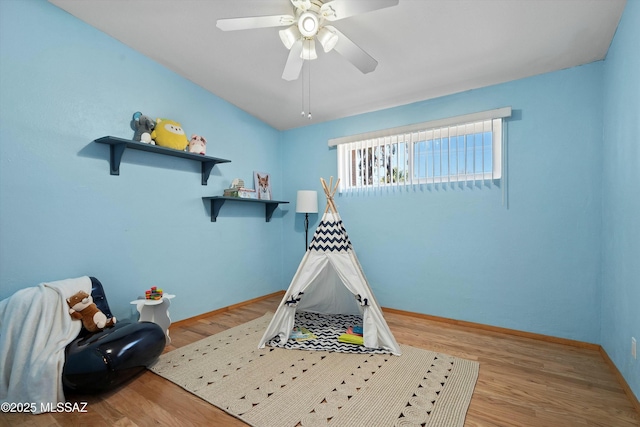 recreation room with light hardwood / wood-style floors and ceiling fan