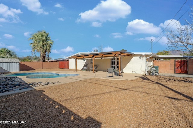 back of property with a patio area and a fenced in pool