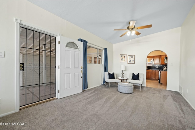 living area with ceiling fan, light carpet, and lofted ceiling