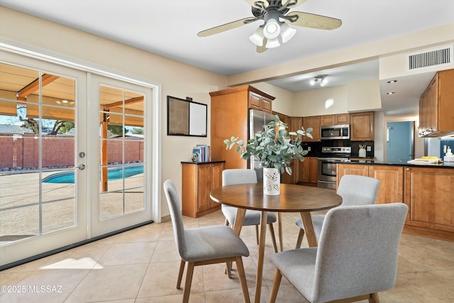 tiled dining room with ceiling fan and french doors