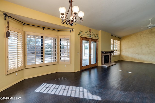 interior space with dark wood-type flooring, lofted ceiling, ceiling fan with notable chandelier, and french doors