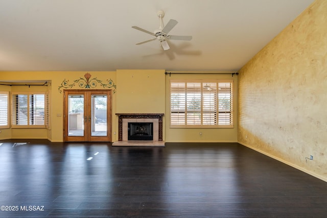 unfurnished living room with dark hardwood / wood-style floors, ceiling fan, a fireplace, and french doors