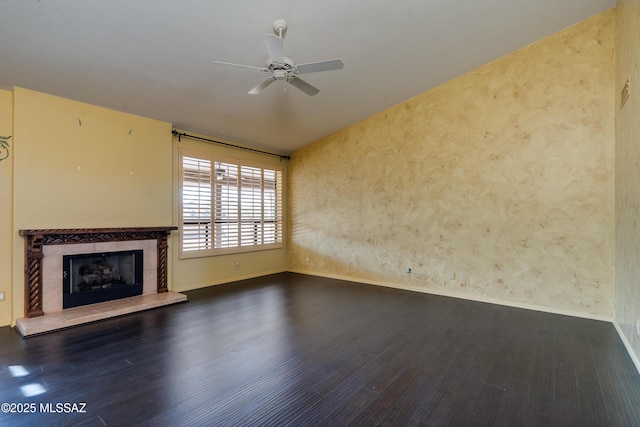 unfurnished living room featuring vaulted ceiling, a tile fireplace, dark hardwood / wood-style floors, and ceiling fan