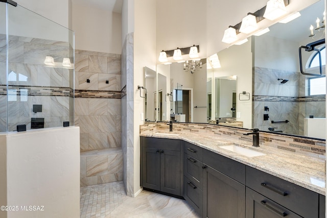 bathroom featuring tiled shower, vanity, and backsplash