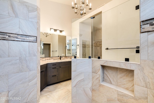 bathroom with vanity, a notable chandelier, and a shower with door