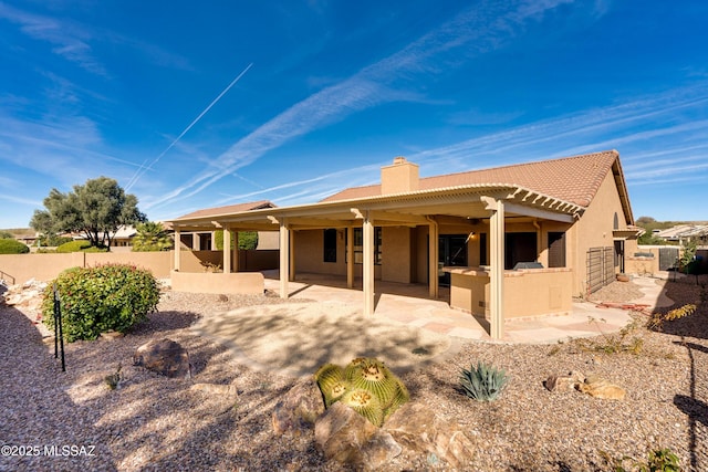 back of property with exterior kitchen and a patio area