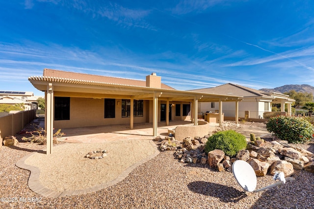 rear view of property with a mountain view and a patio