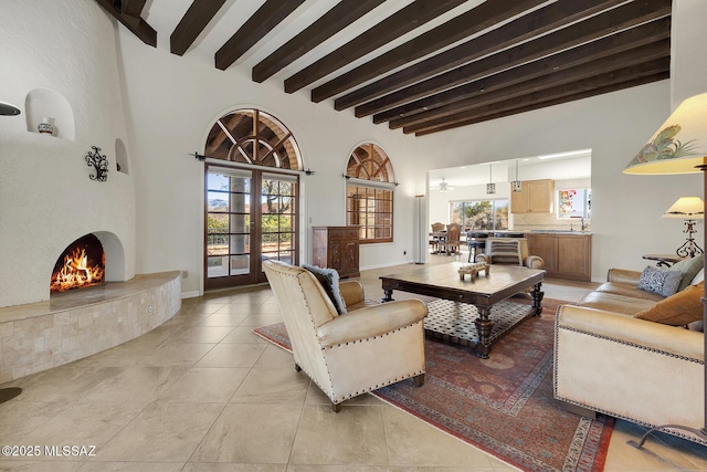 tiled living room featuring a high ceiling, a large fireplace, french doors, and beamed ceiling