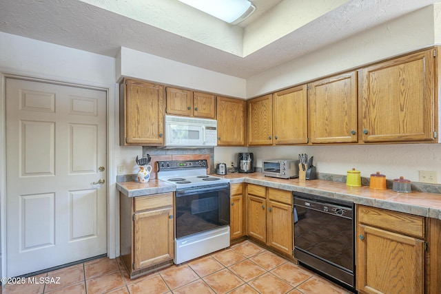 kitchen with light tile patterned floors, white appliances, tile countertops, and a textured ceiling