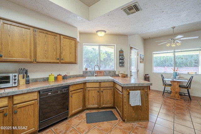 kitchen with sink, a textured ceiling, dishwasher, and light tile patterned flooring