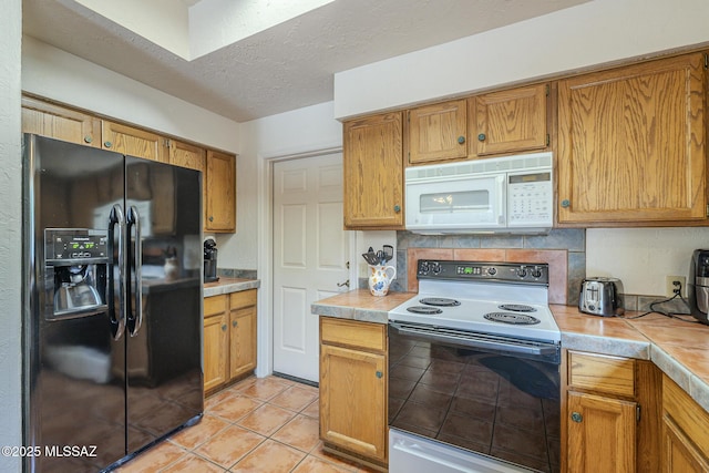 kitchen with range with electric cooktop, tasteful backsplash, light tile patterned floors, black fridge with ice dispenser, and a textured ceiling