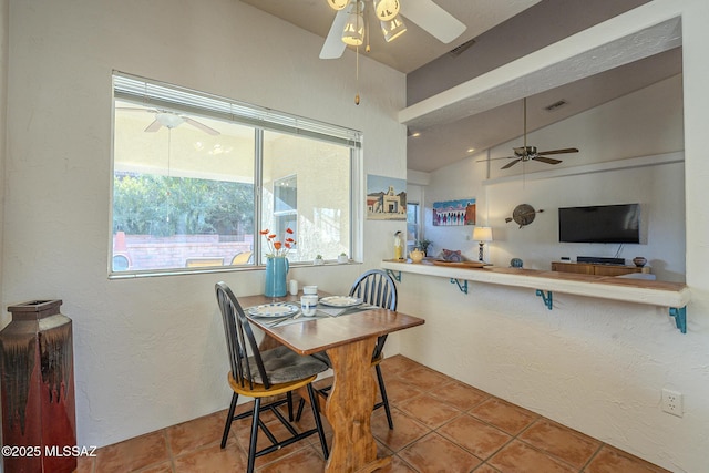 tiled dining space featuring vaulted ceiling and ceiling fan