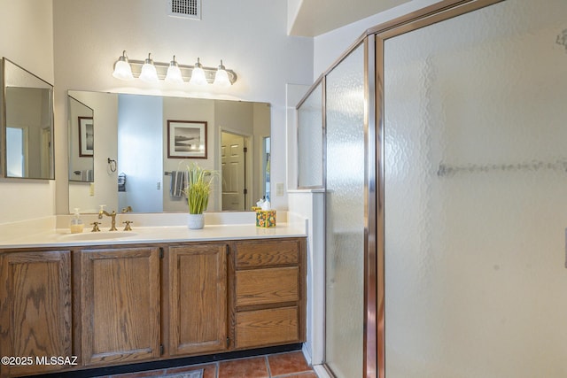 bathroom with tile patterned floors, vanity, and a shower with door