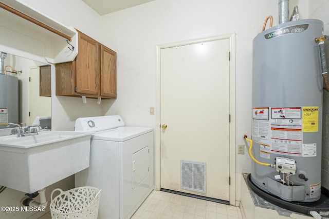 washroom with washer / clothes dryer, sink, cabinets, and water heater