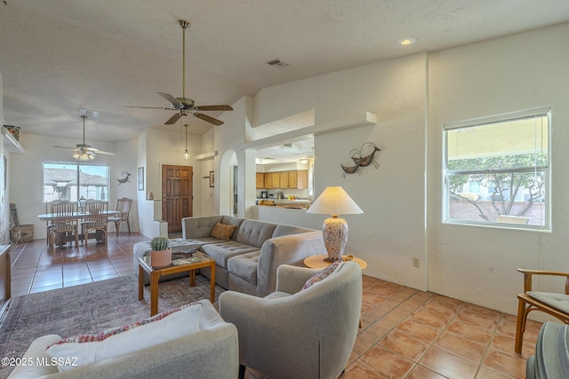 tiled living room with vaulted ceiling and ceiling fan