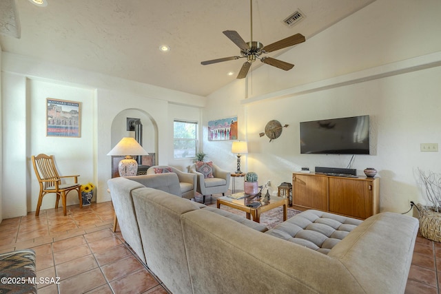 tiled living room featuring ceiling fan and vaulted ceiling