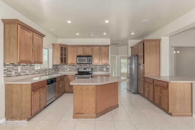 kitchen with sink, a center island, decorative backsplash, and stainless steel appliances