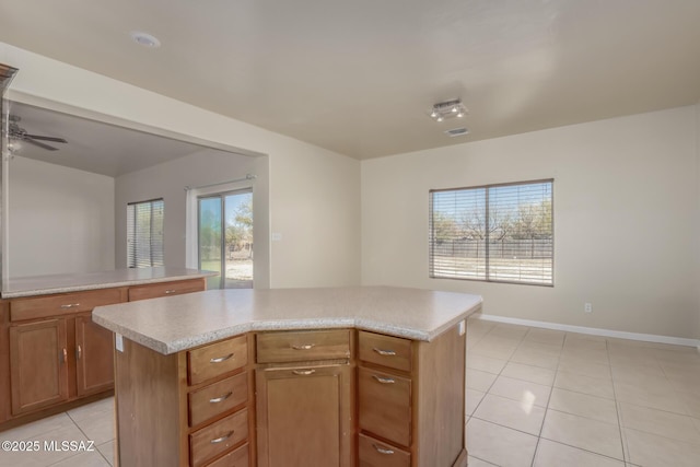 kitchen with a kitchen island, light tile patterned flooring, and ceiling fan