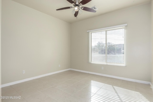 tiled spare room with ceiling fan