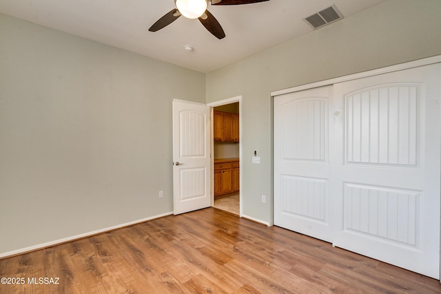 unfurnished bedroom with ceiling fan, a closet, and light wood-type flooring