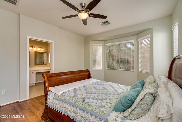 bedroom featuring ceiling fan, connected bathroom, and dark hardwood / wood-style flooring