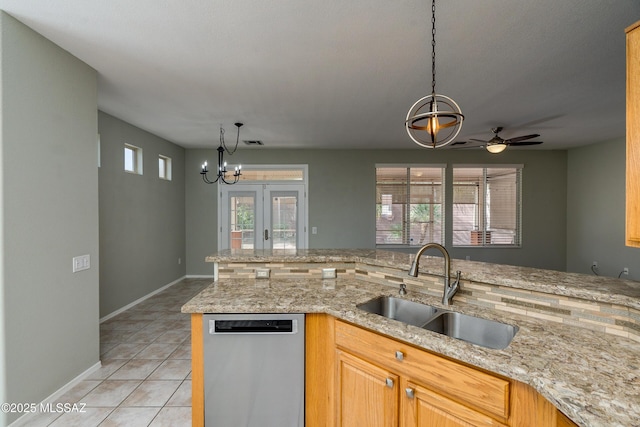 kitchen with light tile patterned flooring, sink, light stone counters, decorative light fixtures, and dishwasher