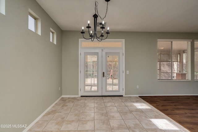 doorway to outside featuring french doors, an inviting chandelier, and light tile patterned floors