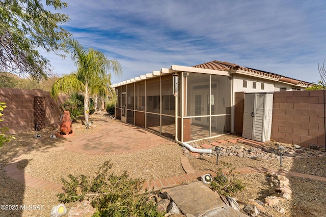 rear view of property featuring a patio and a sunroom