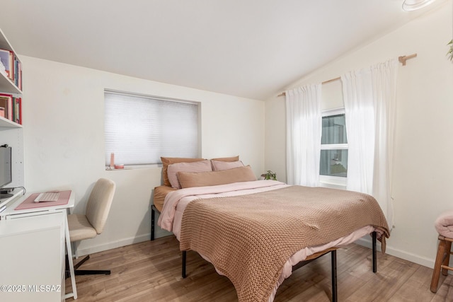 bedroom with lofted ceiling and light hardwood / wood-style floors