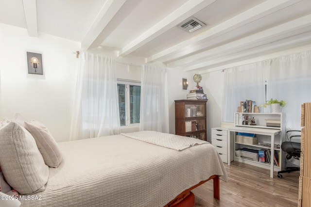 bedroom featuring wood-type flooring and beam ceiling