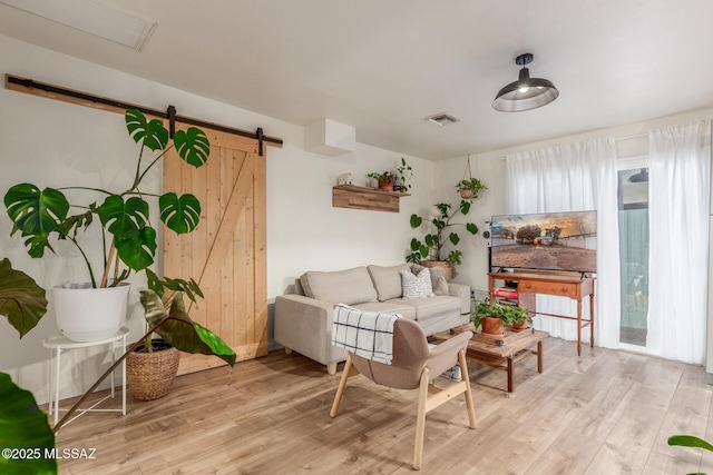 living room featuring a barn door and light hardwood / wood-style floors