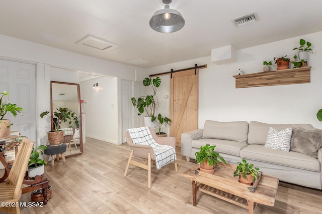 living room featuring a barn door and light wood-type flooring