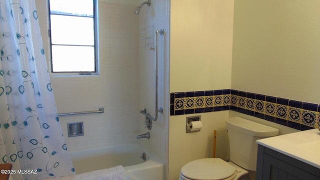 full bathroom with toilet, shower / bathtub combination with curtain, tile walls, and a wealth of natural light