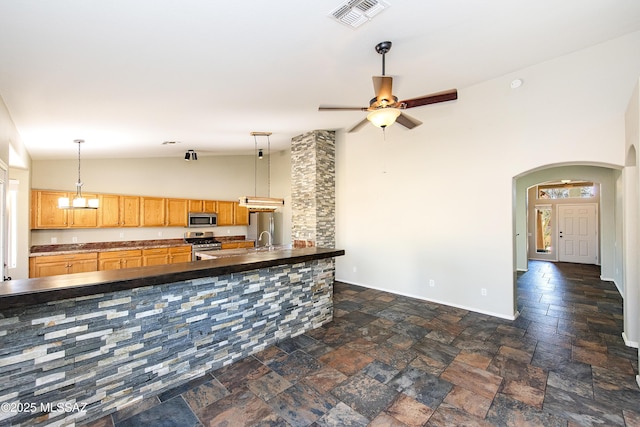 kitchen featuring stainless steel appliances, sink, high vaulted ceiling, and decorative light fixtures