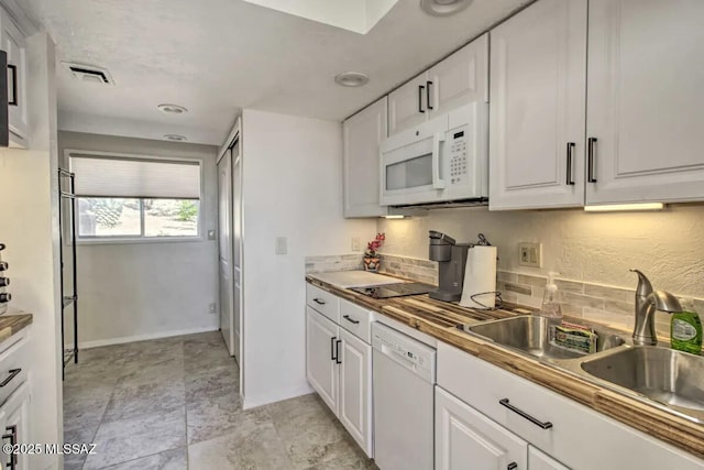 kitchen with white appliances, sink, and white cabinets