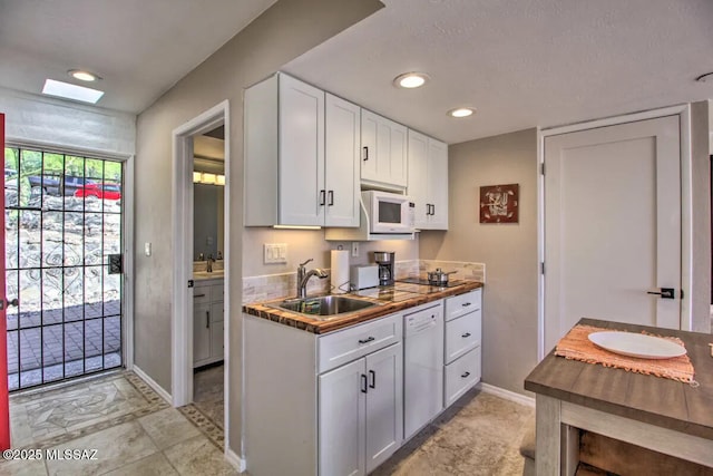 kitchen featuring white cabinetry, white appliances, and sink