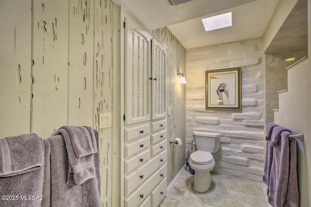 bathroom featuring toilet and a skylight