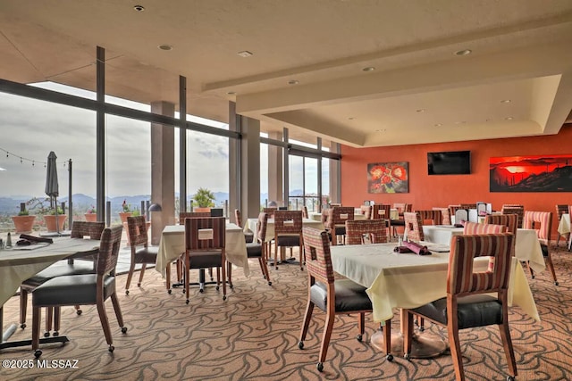 carpeted dining room featuring floor to ceiling windows