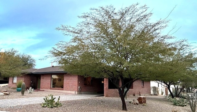 view of front facade featuring brick siding and driveway