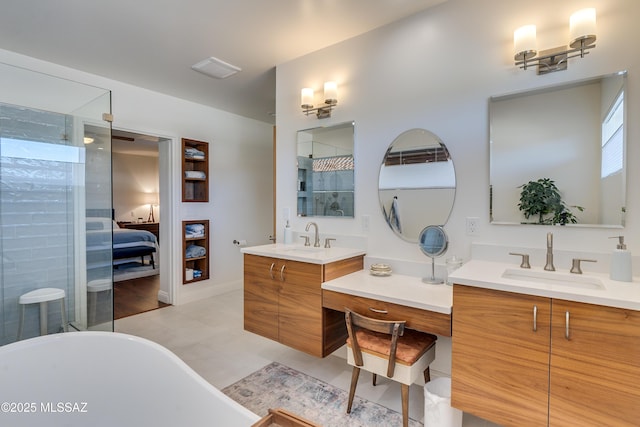 ensuite bathroom with a sink, a freestanding tub, tiled shower, and two vanities