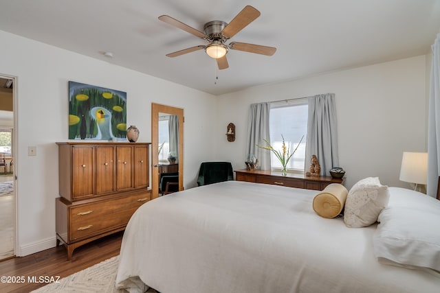 bedroom with baseboards, wood finished floors, and a ceiling fan